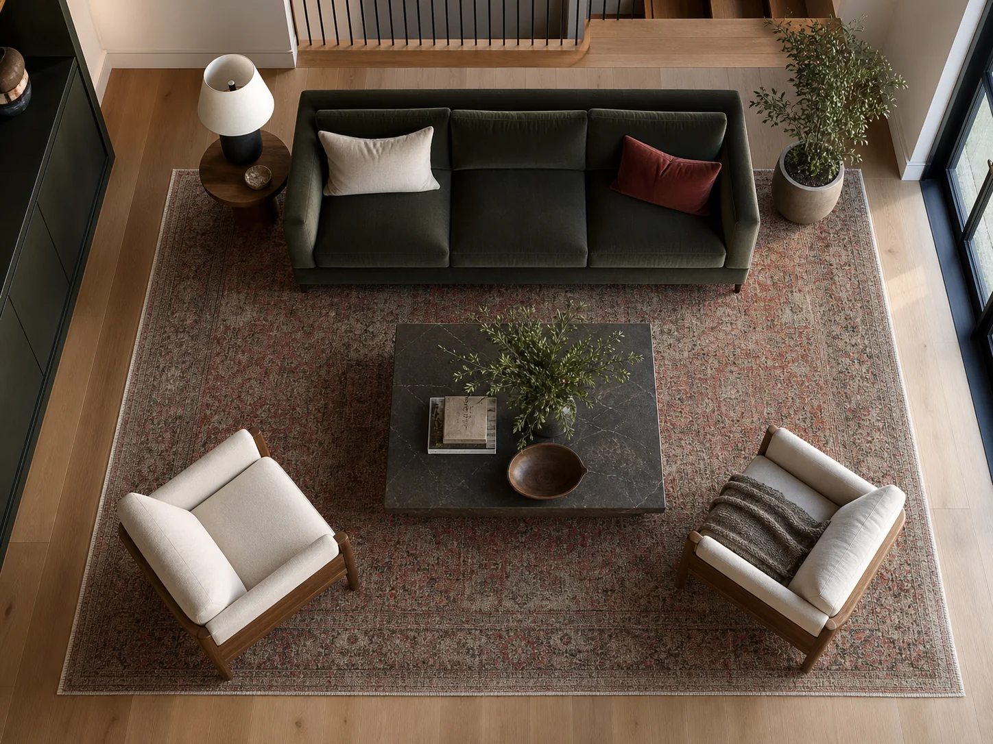 Overhead view of a sofa and two chairs anchored by a large patterned rug