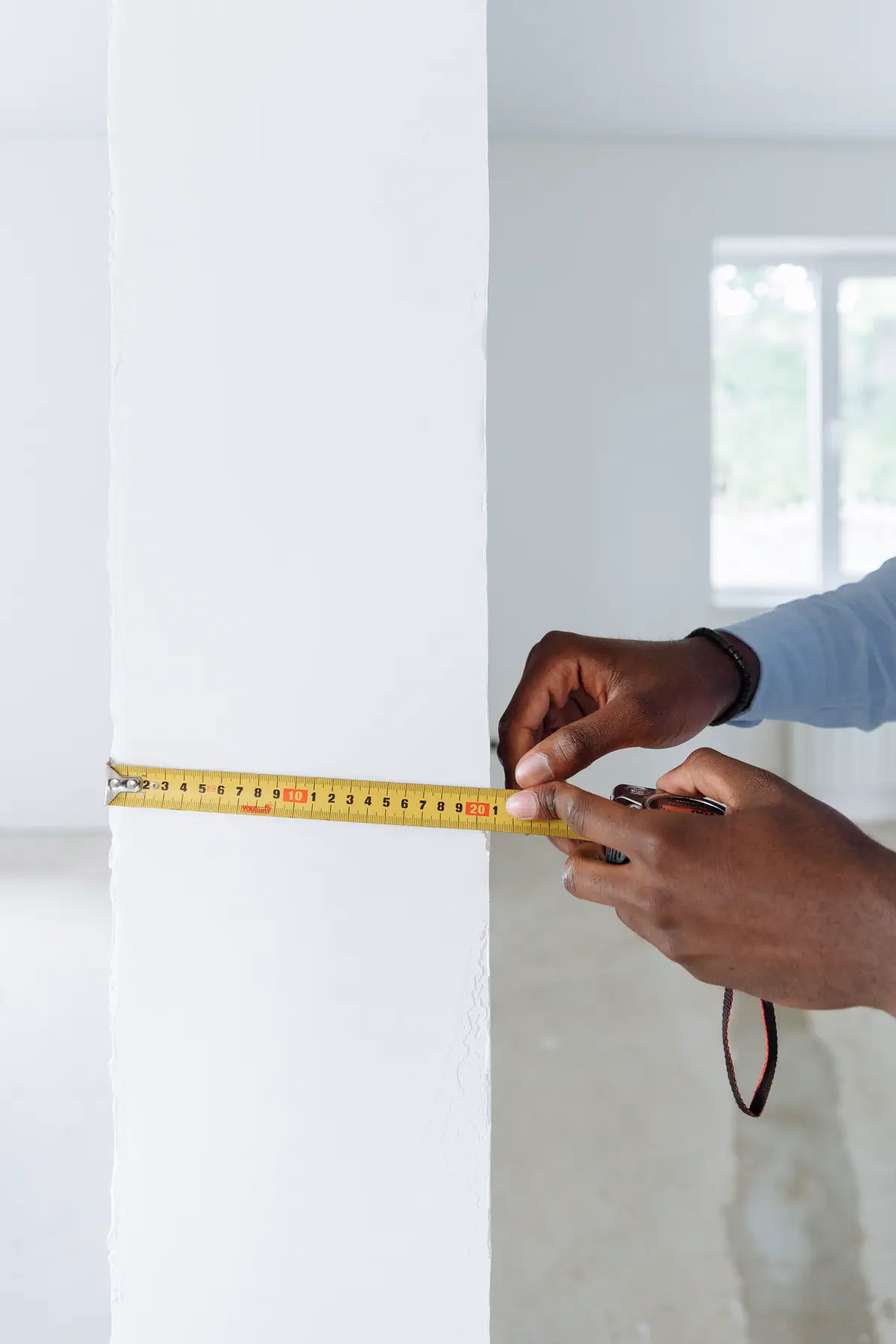 A tape measure checking the clear width of a wall